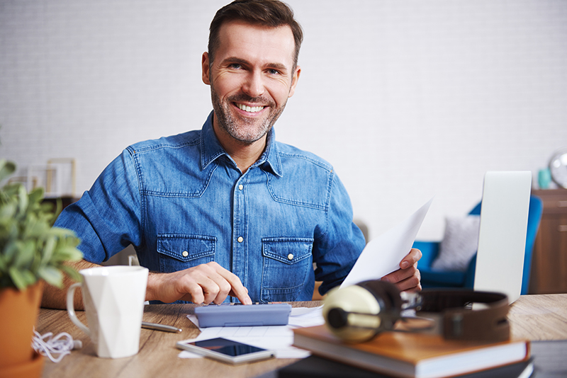 portrait-smiling-man-calculating-his-monthly-expenses.jpg